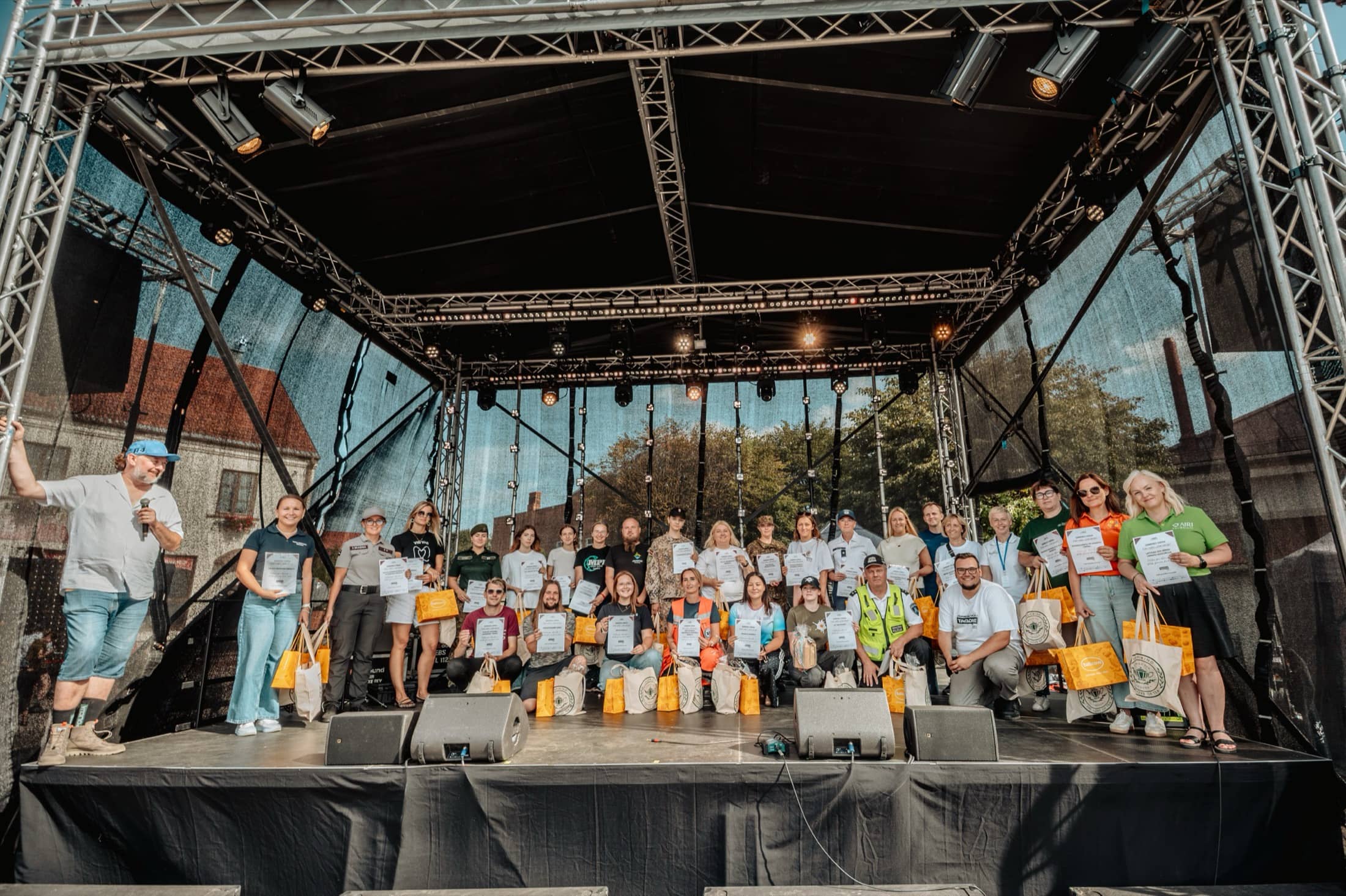 Laiks Jauniešiem pasākuma dalībnieki uz skatuves ar pateicības rakstiem
