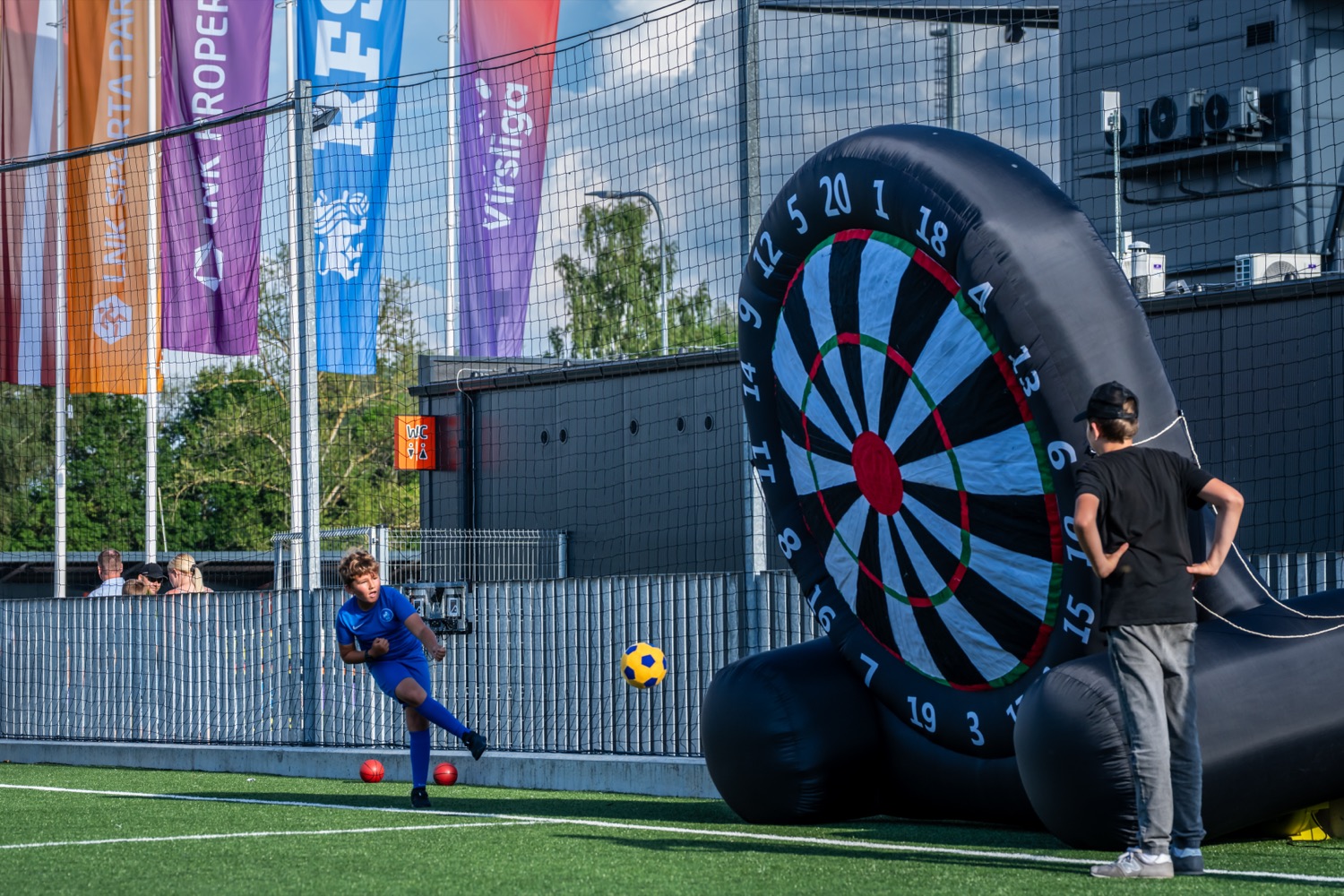 A boy kicking a ball at the giant football target