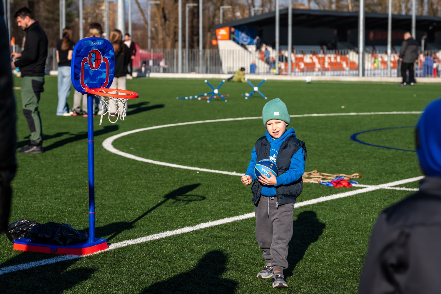 A child with a ball at a kids' basketball hoop
