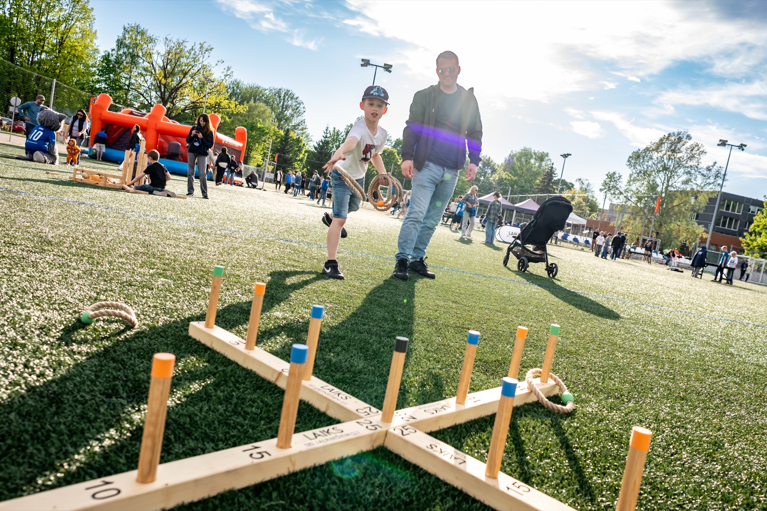 Ring toss game at an event, club mascot in the background