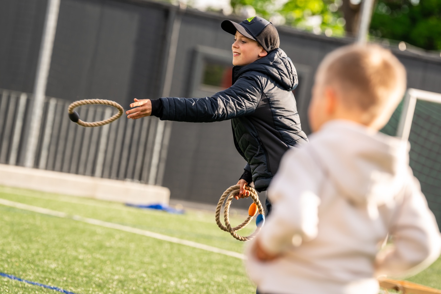 A boy throwing a ring in the ring toss game