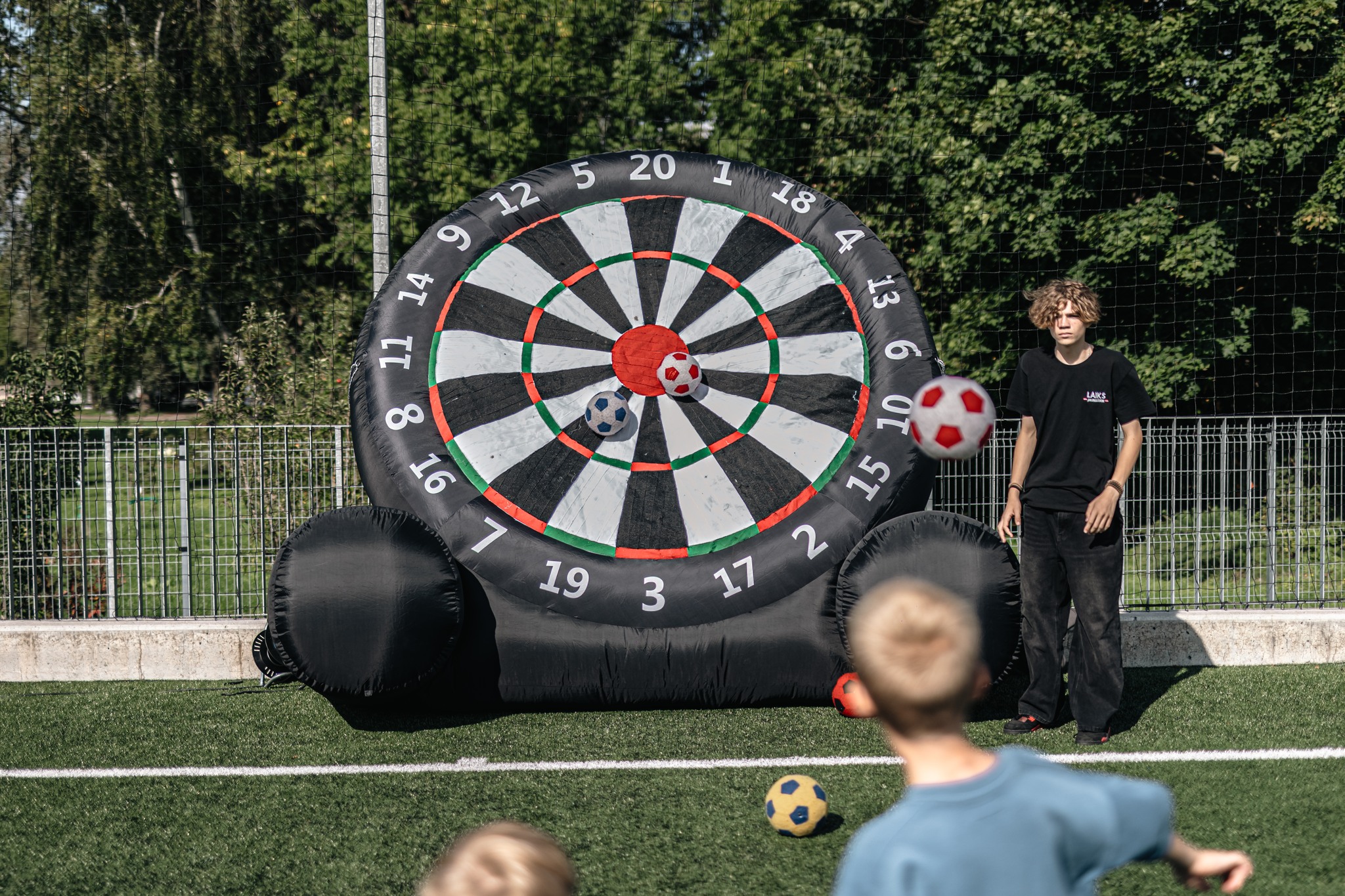 May be an image of 3 people, dartboard and text