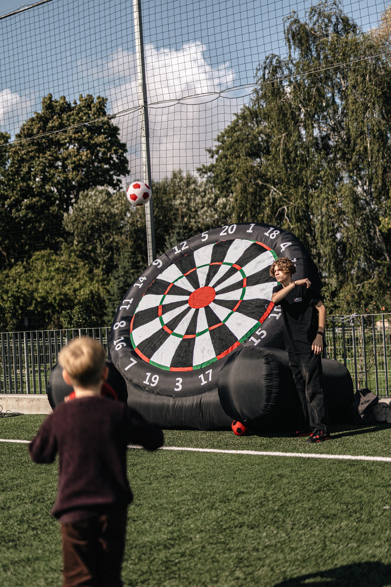 May be an image of 3 people, people playing football, people playing soccer, frisbee and dartboard