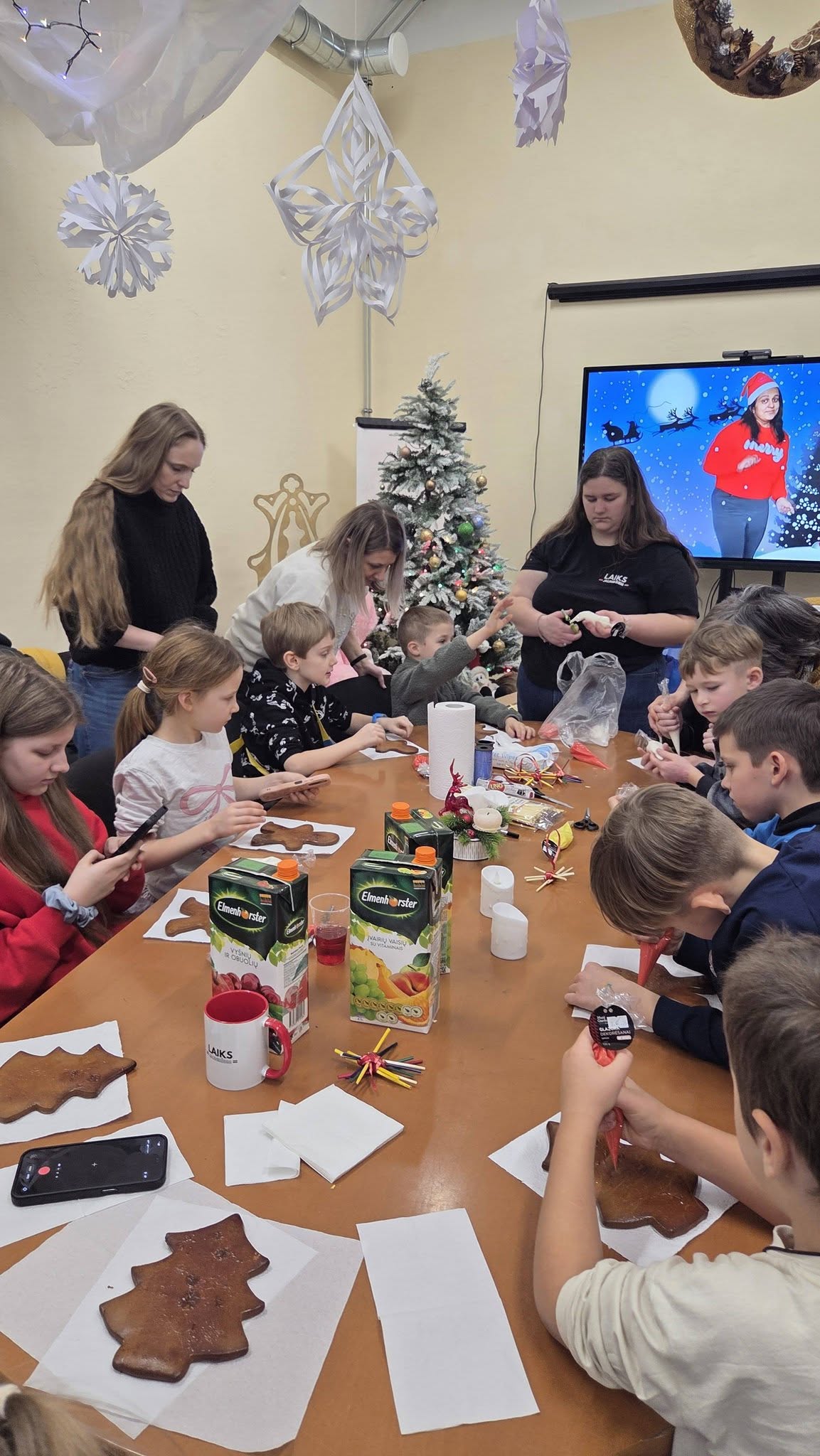 May be an image of studying, gingerbread cookie, christmas tree, table and text