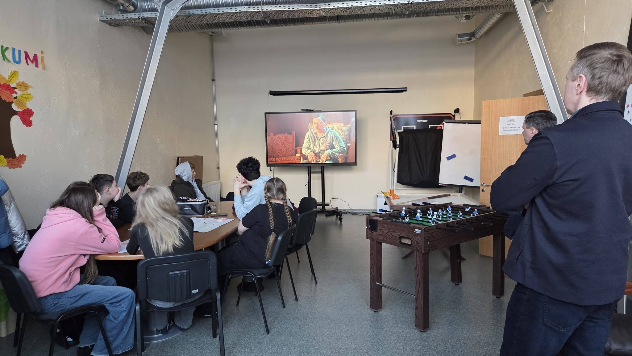 May be an image of studying, television, dartboard and table